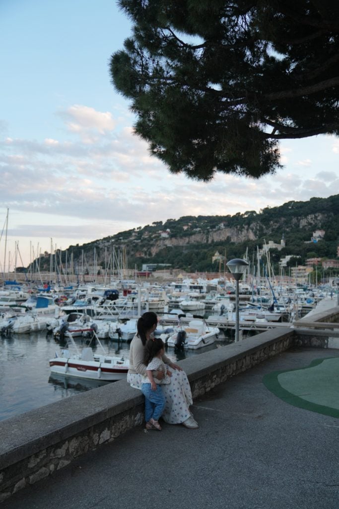 Woman and child sitting beside Port de la Darse marina