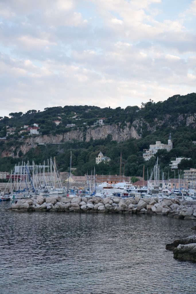 Sailboats moored at Port de la Darse below wooded cliffs