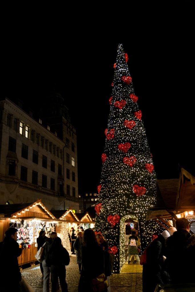 Illuminated Christmas tree and market stalls at night in Copenhagen
