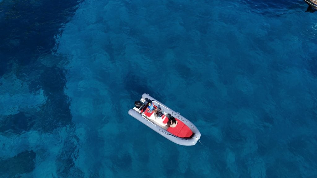 Jessica's dinghy with skipper on the turquoise Gulf of Orosei