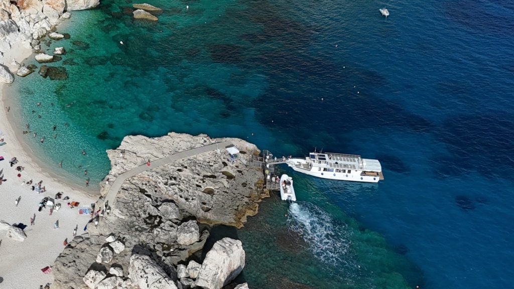 Group boat tour stopping at the white pebble beach of Cala Mariolu