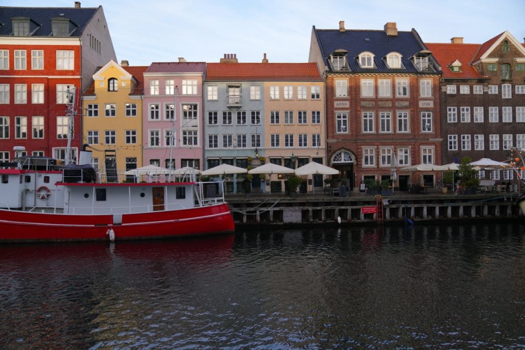 Red boat moored beside colorful buildings in Nyhavn