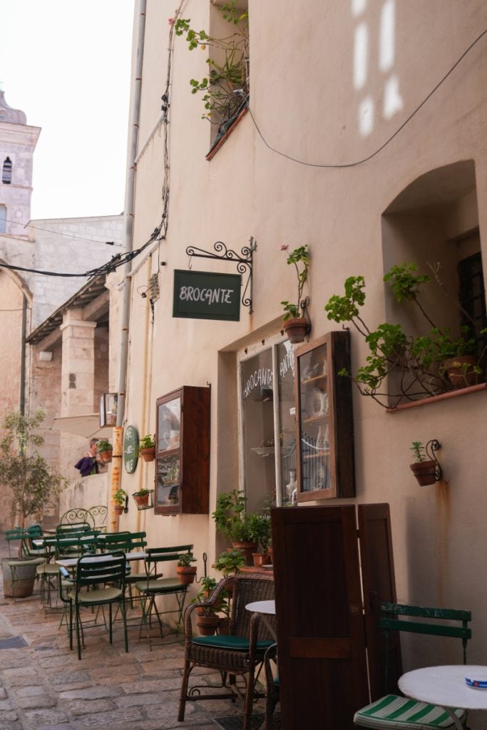 Cobblestone street lined with restaurants in Bonifacio's citadel