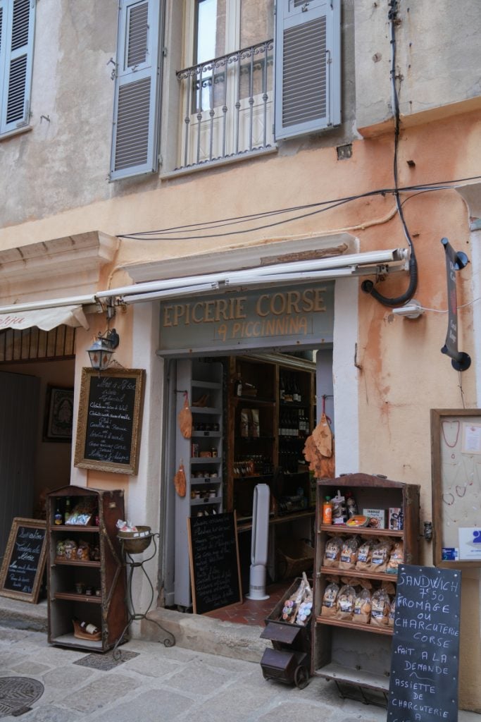 Shelves of Corsican oils and preserves at A piccinnina in Bonifacio