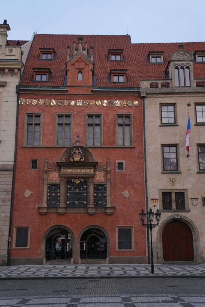 Ornate red facade on a historic square in Prague