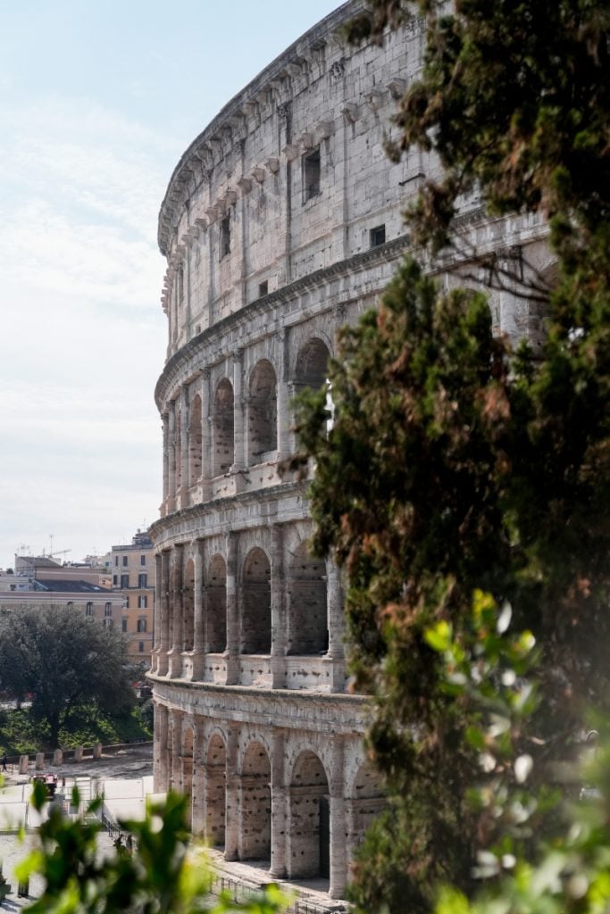 Colosseum's arched exterior framed by trees