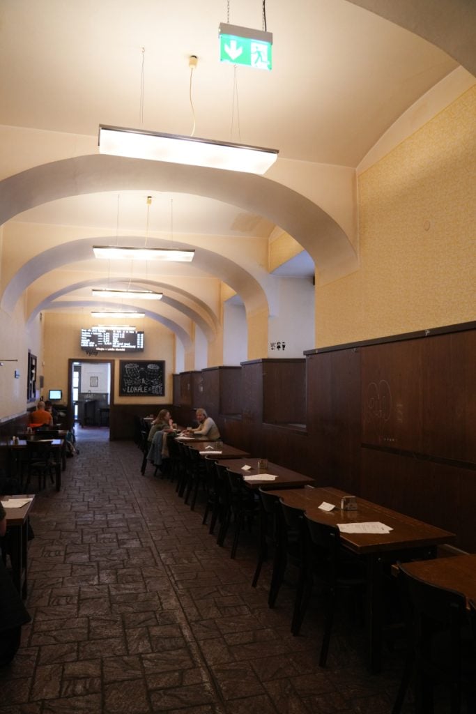 Arched dining room with rows of tables at Lokal