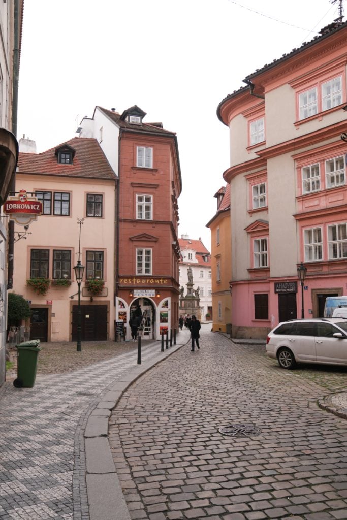 Pastel historic buildings along a cobblestone Malá Strana street
