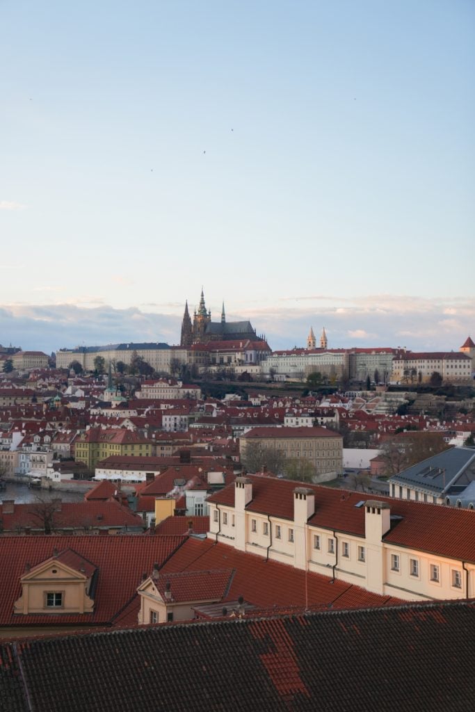 Prague Castle and red rooftops viewed from the Klementinum tower