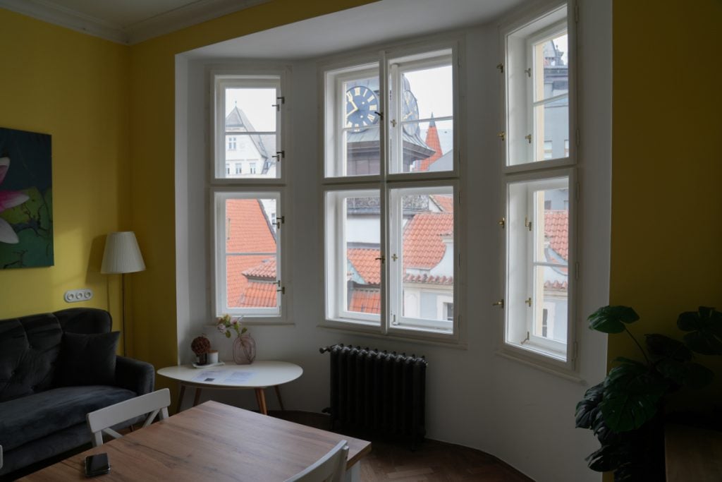 Bright living room with yellow walls in a Prague Airbnb