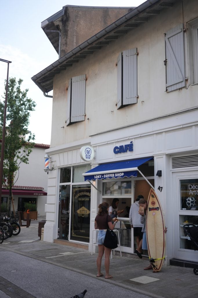 Café Loky storefront with customers and a surfboard