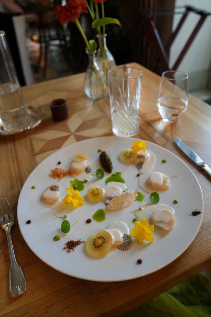 Fine dining dish with kiwi and edible flowers at Gaztelur