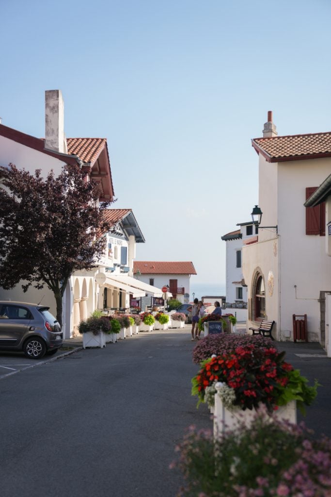 Flower-lined street leading toward the sea in Guéthary