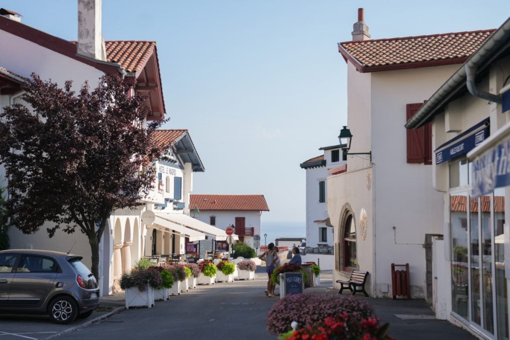 Flower-lined street leading toward the sea in Guéthary
