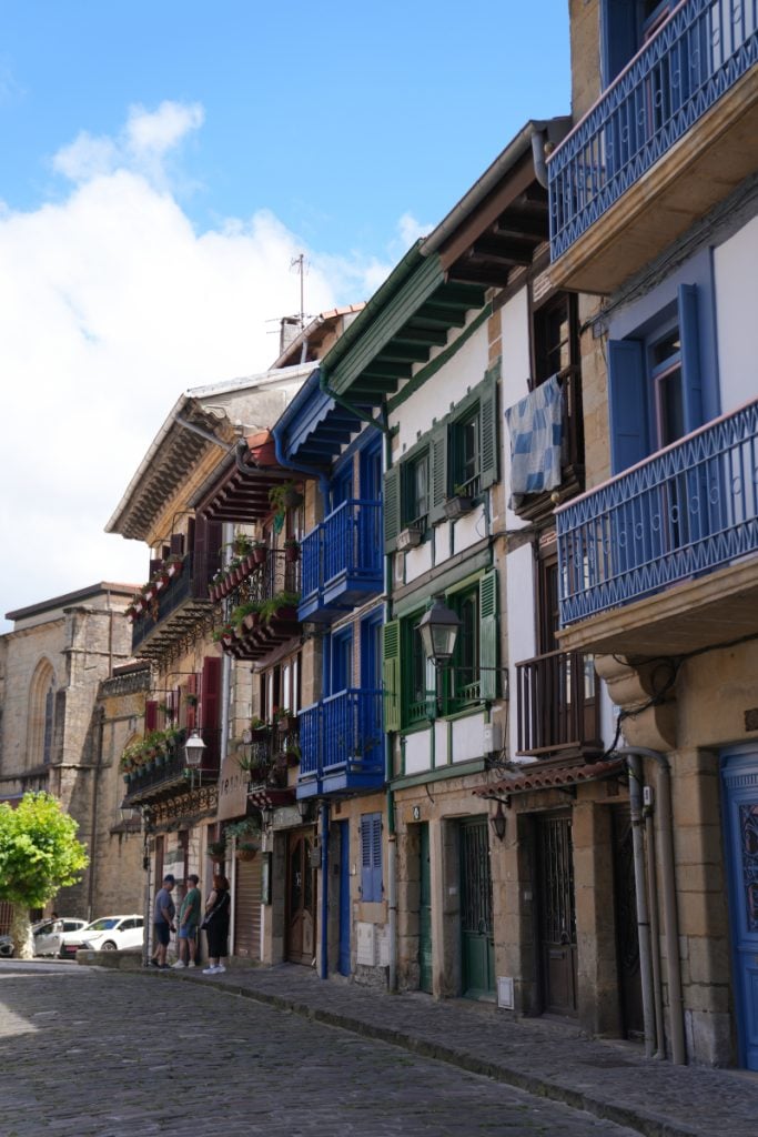 Colorful balconies lining a cobblestone street in Hondarribia's Old Town
