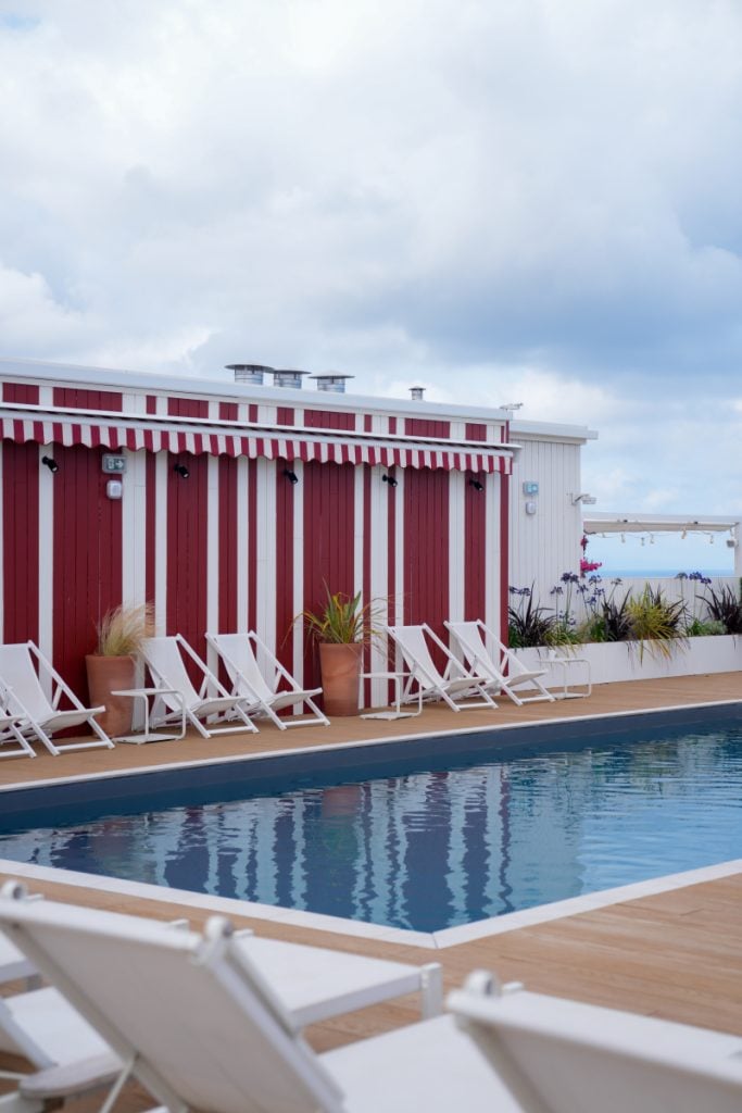 Le Talaia rooftop pool beside red-and-white striped building