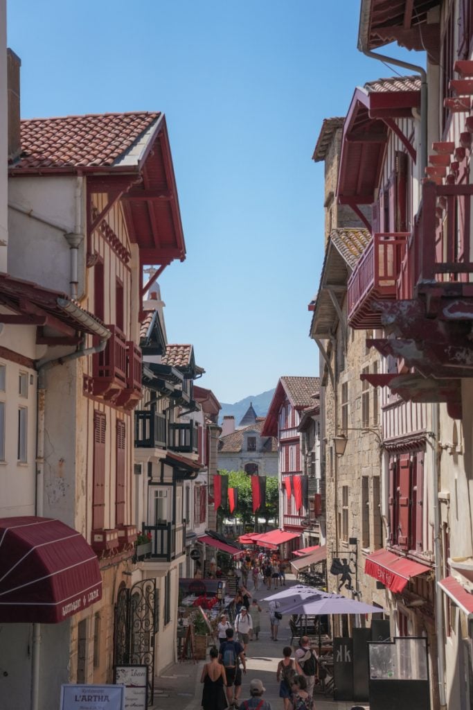 Pedestrian street with red balconies in Saint-Jean-de-Luz