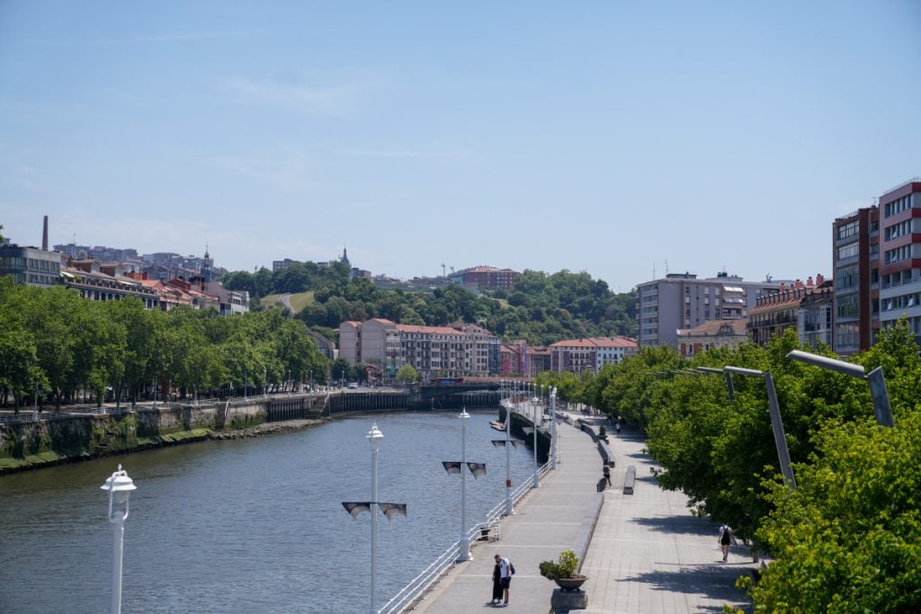 Bilbao riverside promenade lined with trees and buildings