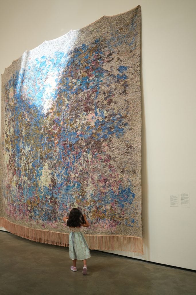 Child viewing a large abstract tapestry at the Guggenheim
