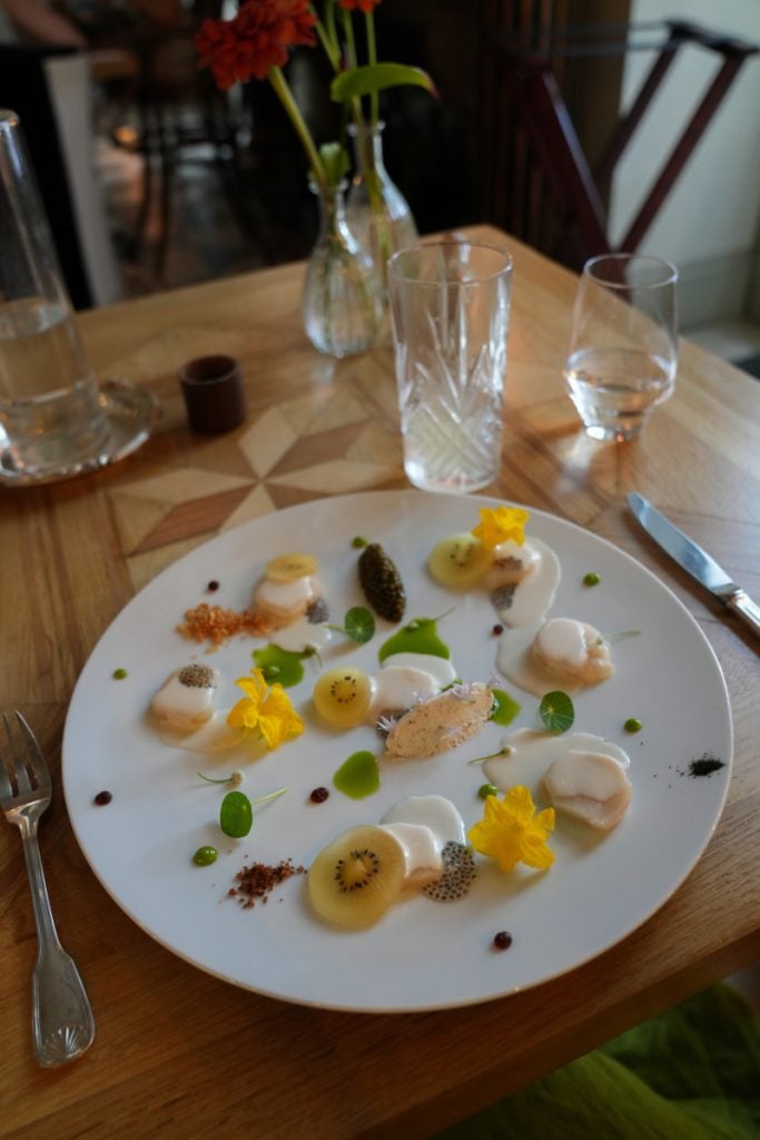 Plated scallops with fruit and edible flowers at Gaztelur