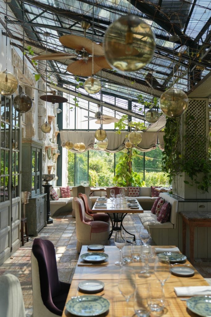 Gaztelur dining room with hanging globe lights and greenery