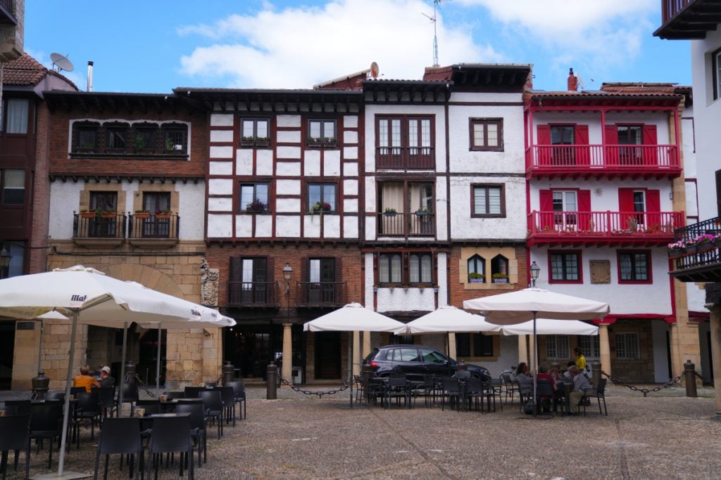 Café tables and colorful balconies in Hondarribia's Plaza de Armas