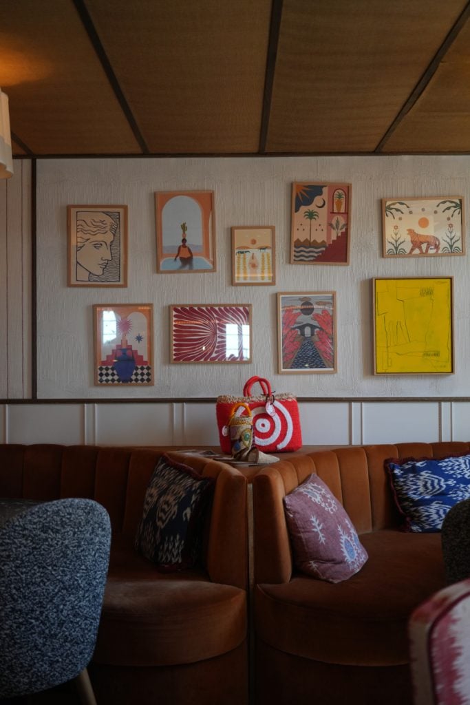 Brown banquette beneath gallery wall at Hotel de Silhouette