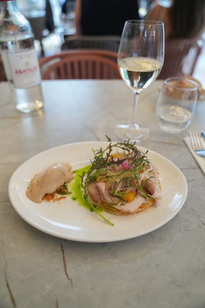 Plated entrée with greens and white wine at Le Saleya