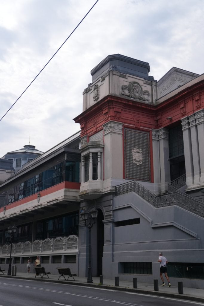 Red and gray facade of Mercado de la Ribera
