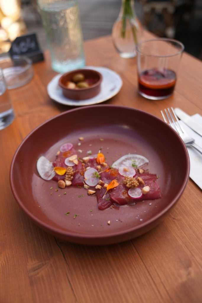 Raw fish with radishes and edible flowers at Ostalapia