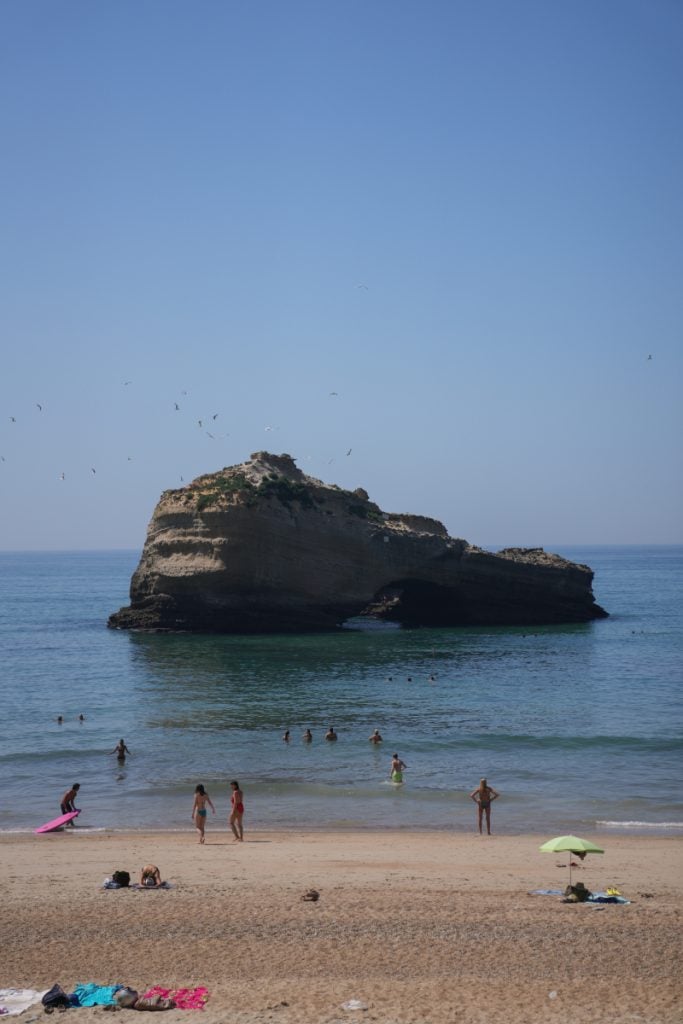 Swimmers beside Le Rocher du Fioup at Plage Miramar