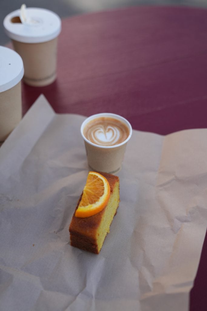 Latte and orange-topped cake at Providence Guéthary
