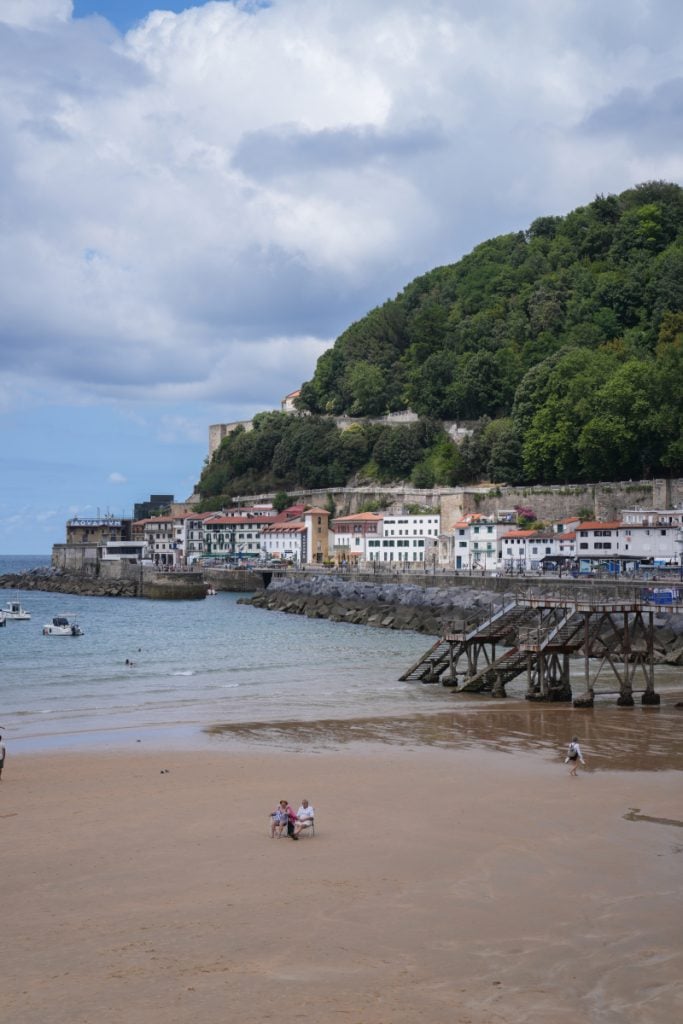 San Sebastián harbor below a tree-covered hillside