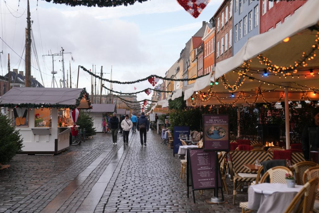 Christmas market stalls beneath garlands along Nyhavn