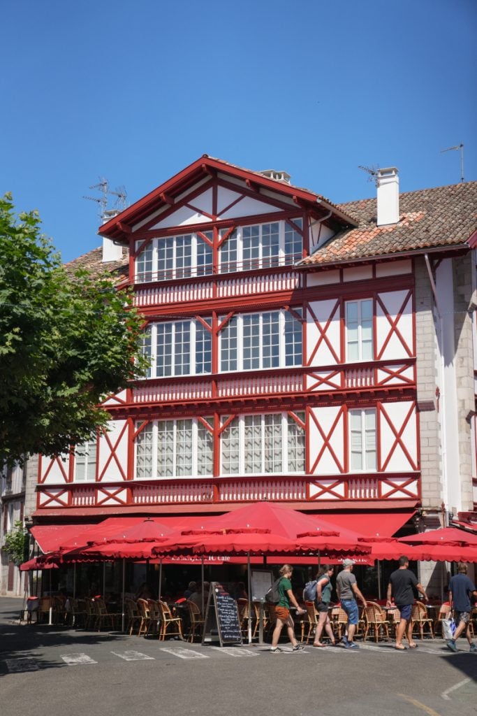 Red-and-white timbered building above a café in Saint-Jean-de-Luz