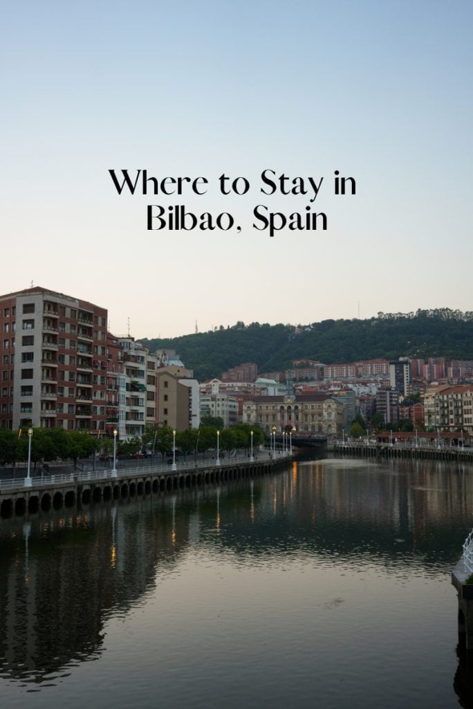 Pinterest graphic: “Where to Stay in Bilbao, Spain” over riverside buildings