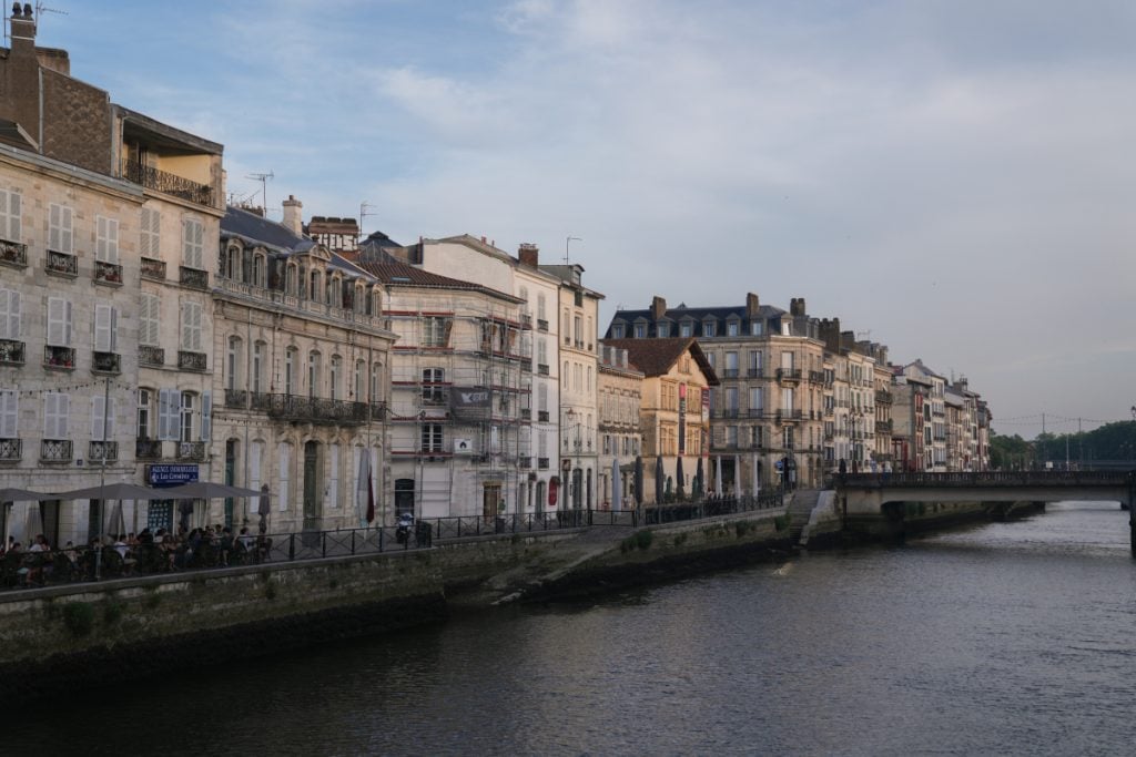 Historic buildings and bridge along the Nive river in Bayonne