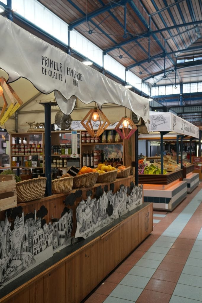 Produce and spice stalls inside Les Halles market