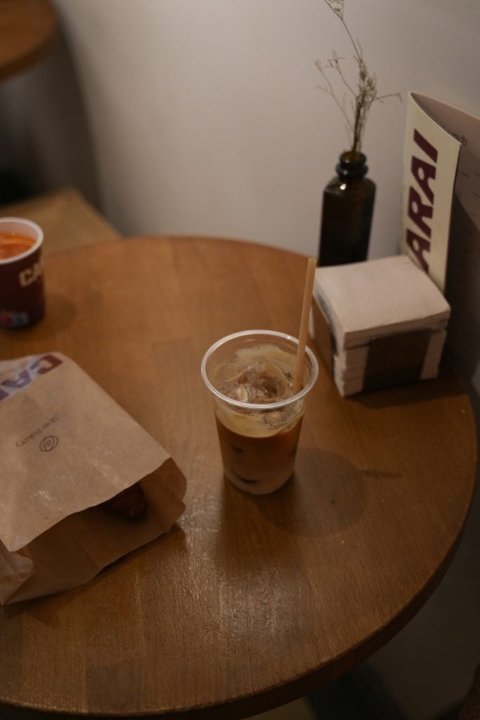 Iced coffee and pastry on a table at Carai