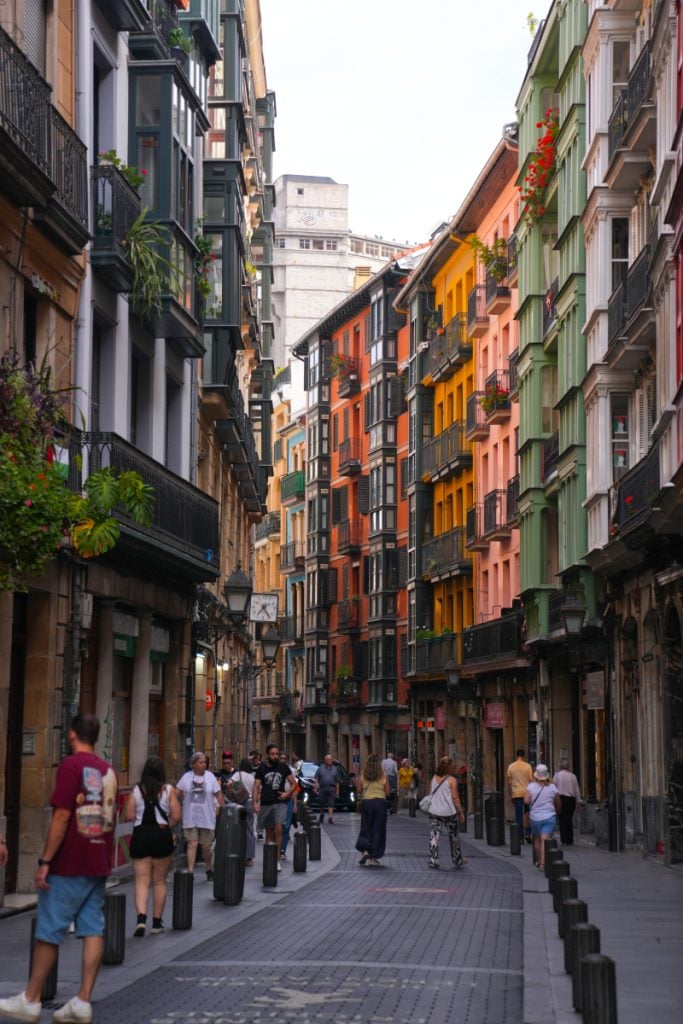 Pedestrians on a colorful street in Bilbao's Casco Viejo