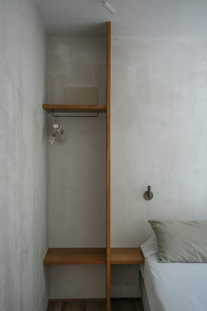 Open wardrobe beside a bed at Enea Living