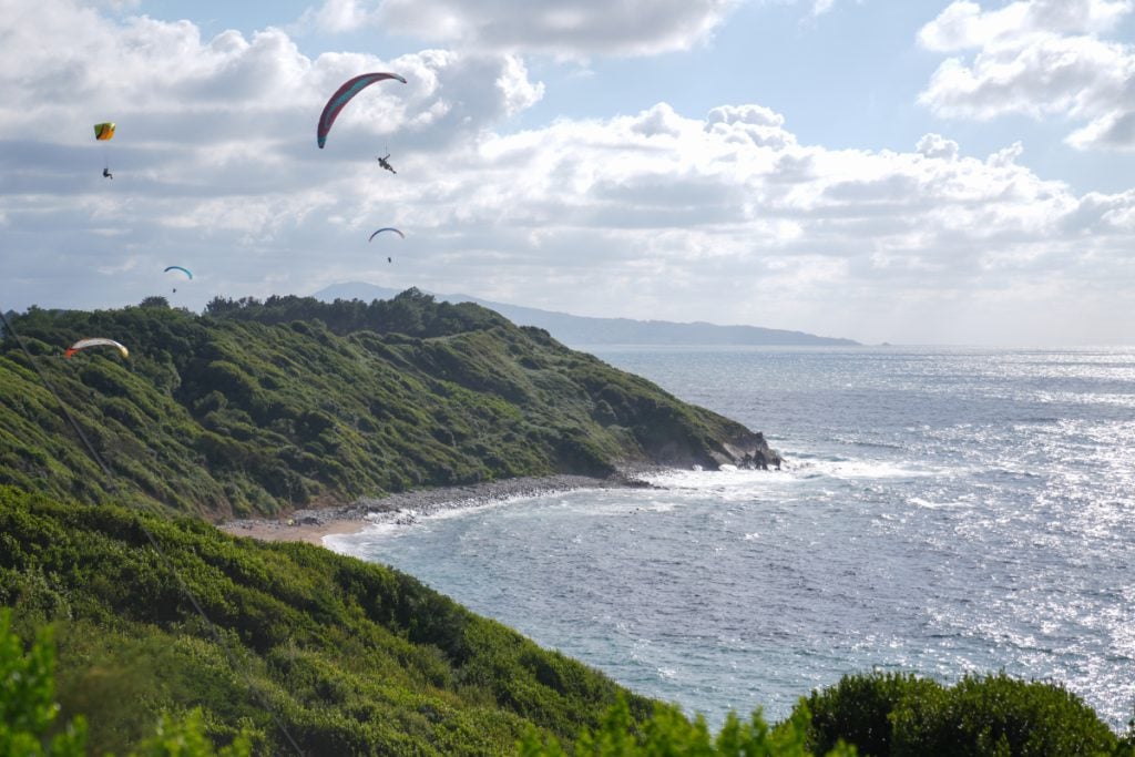 Paragliders above La Corniche Basque's rugged Atlantic coast