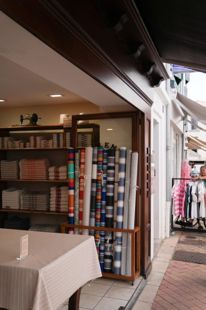 Striped fabric rolls and folded linens inside a shop