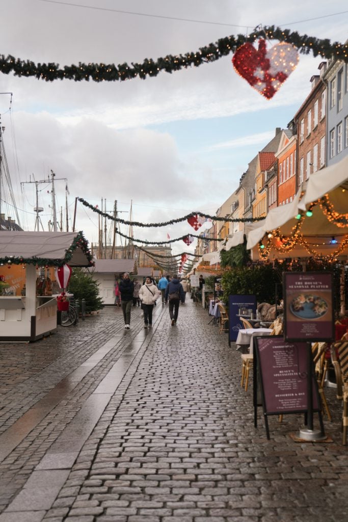 Christmas market stalls along a decorated Nyhavn street