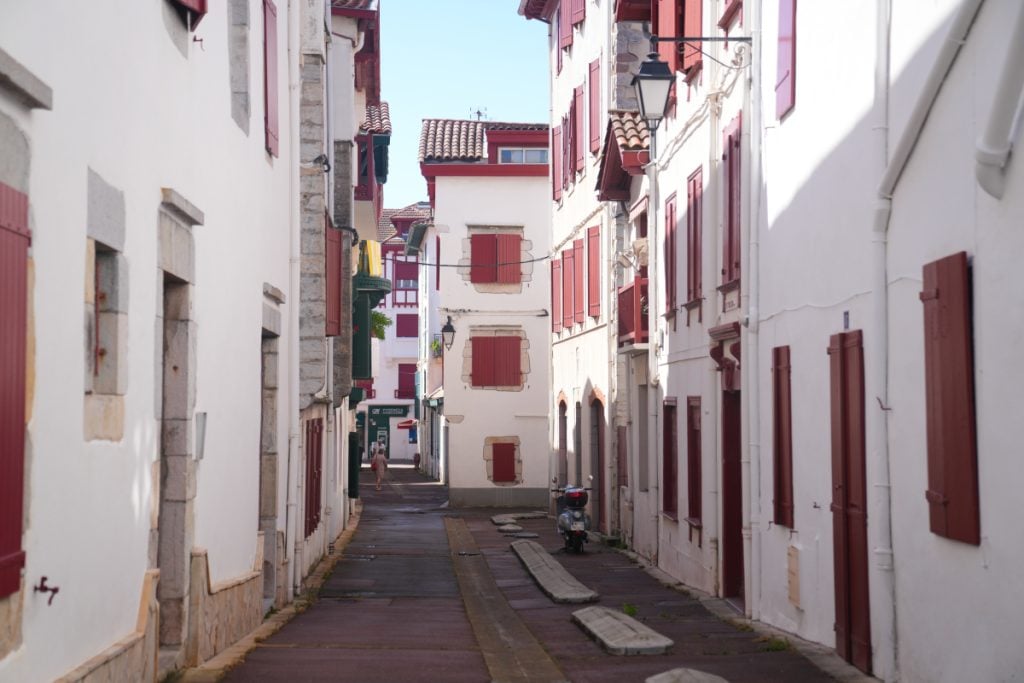 Quiet Saint-Jean-de-Luz street lined with red-shuttered buildings