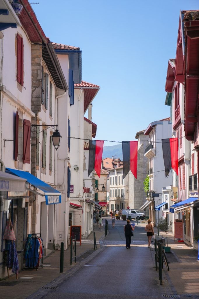Red banners above a narrow Saint-Jean-de-Luz Old Town street