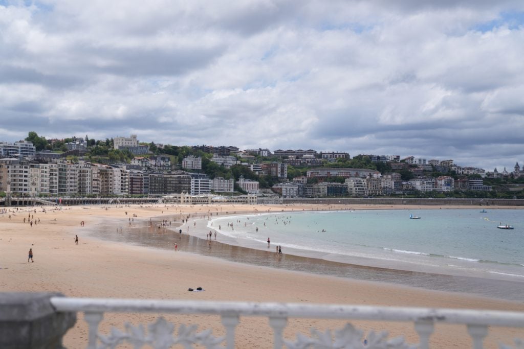 La Concha Beach and San Sebastián waterfront under cloudy skies