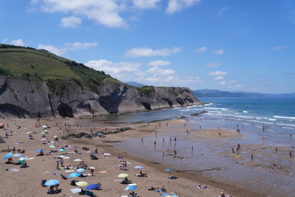 Beachgoers beneath coastal cliffs in Zumaia
