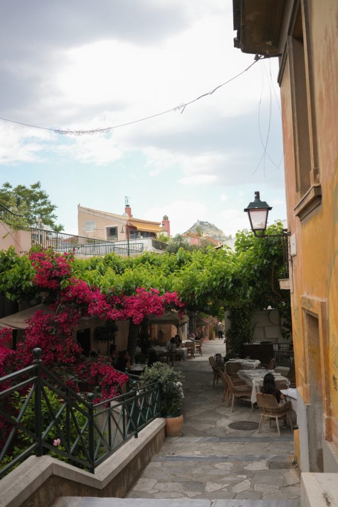 Stone steps descend past bougainvillea-covered restaurants in Anafiotika