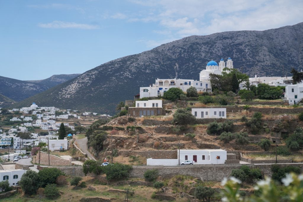 Apollonia hillside with white buildings and a blue-domed church.